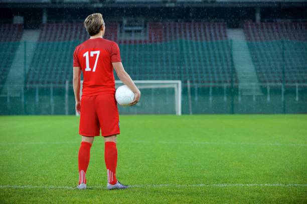 istock Football player standing in stadium 647629948