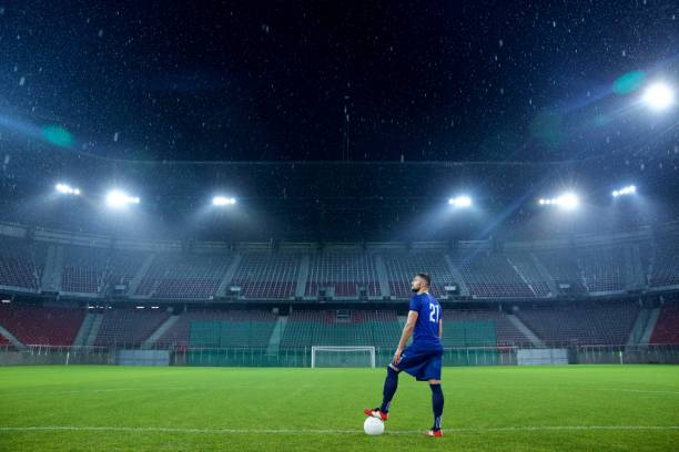 calciatore in piedi allo stadio - football field football number 20 grass foto e immagini stock