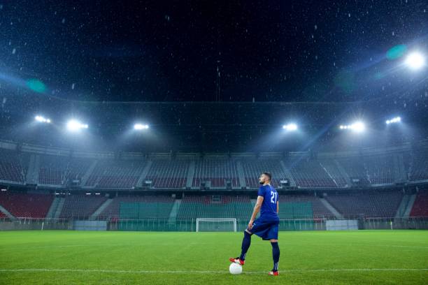 istock Football player standing in stadium 647629952