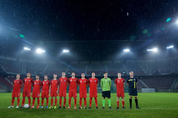istock Football team standing in a row 647629960