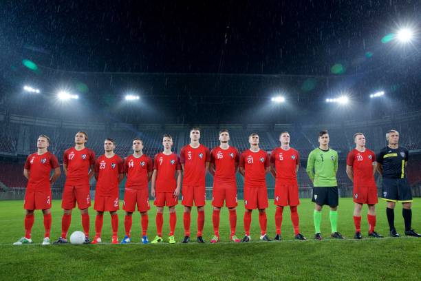 istock Football team standing in a row 647630008