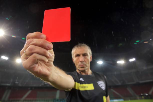 Referee holds up red card Portrait of referee showing red card during football match. referee stock pictures, royalty-free photos & images