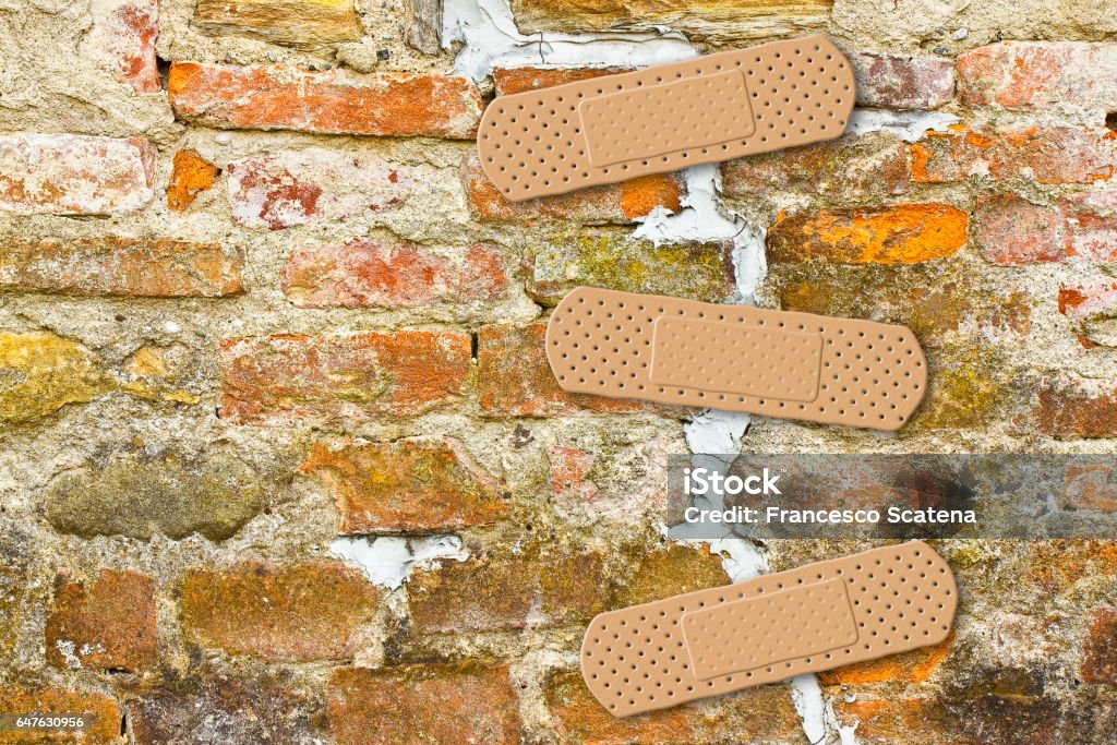 Renovation of cracked brick wall - concept image with copy space Adhesive Bandage Stock Photo