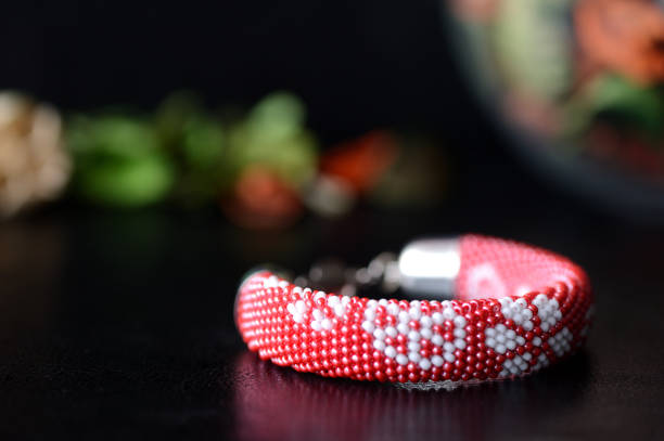 istock Beaded crochet bracelet with floral print on a dark background 647633158