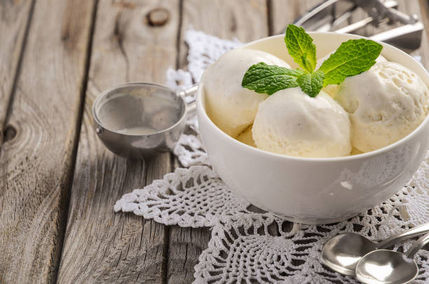 istock Vanilla ice cream with mint leaves in white bowl on rustic wooden background 647644428