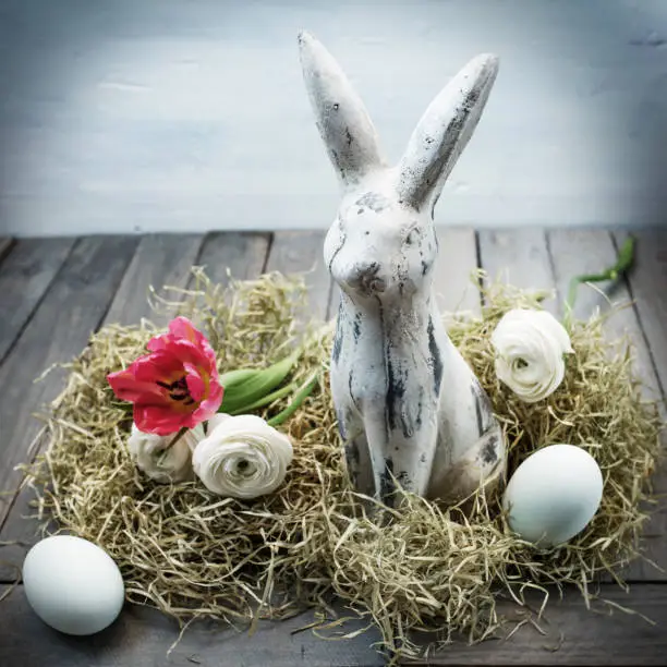 Easter nest with eggs and a bunny in shabby chic style on a wooden table