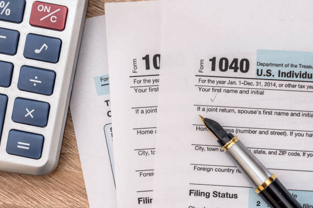 istock 2017 year tax form 1040 with calculator and pen. 647649110