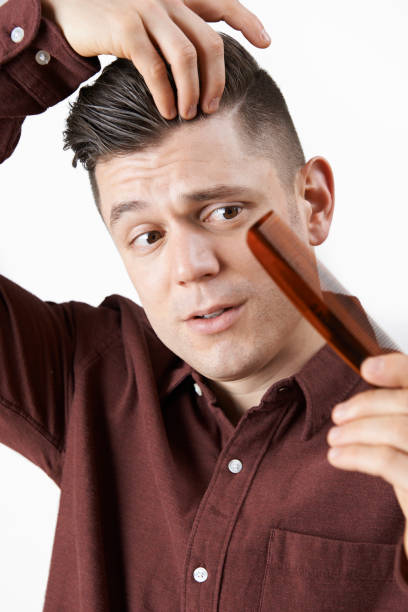istock Man With Comb Corncerned About Hair Loss 647653592