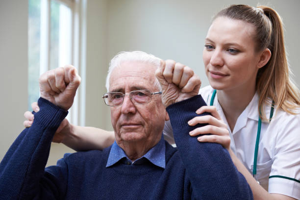 Nurse Assessing Stroke Victim By Raising Arms Nurse Assessing Stroke Victim By Raising Arms stroke illness stock pictures, royalty-free photos & images