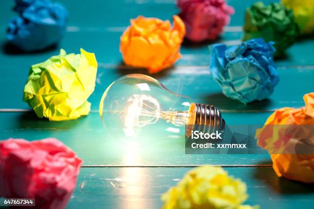 Incandescent Bulb And Colorful Notes On Turquoise Wooden Table Stock Photo - Download Image Now