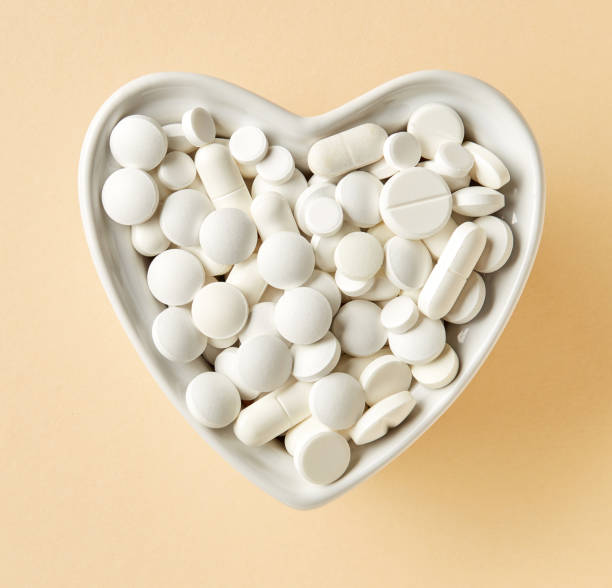 istock heart shaped bowl of white pills 647661192