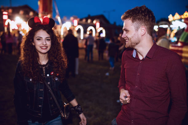istock Couple in luna park smiling at each other 647661312