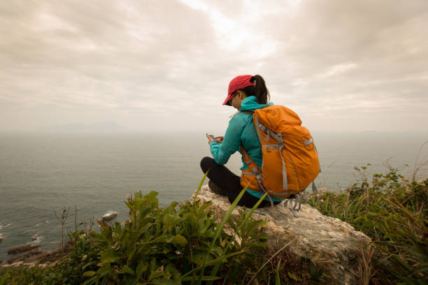 istock successful hiker use cellphone on seaside mountain peak rock 647661826