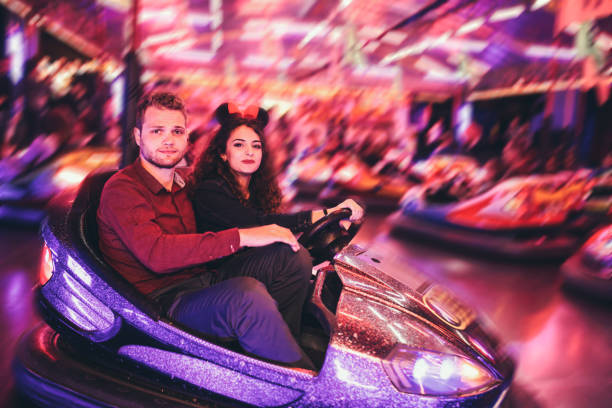 istock Young couple posing in a bumper car amusement park 647664962
