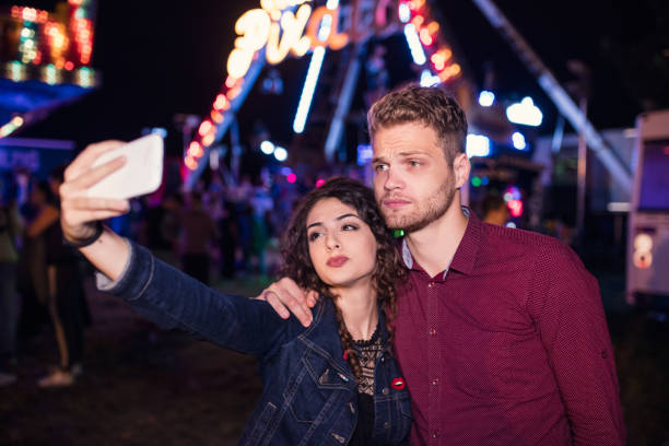 istock Young couple serious face selfie , amusement park 647665068