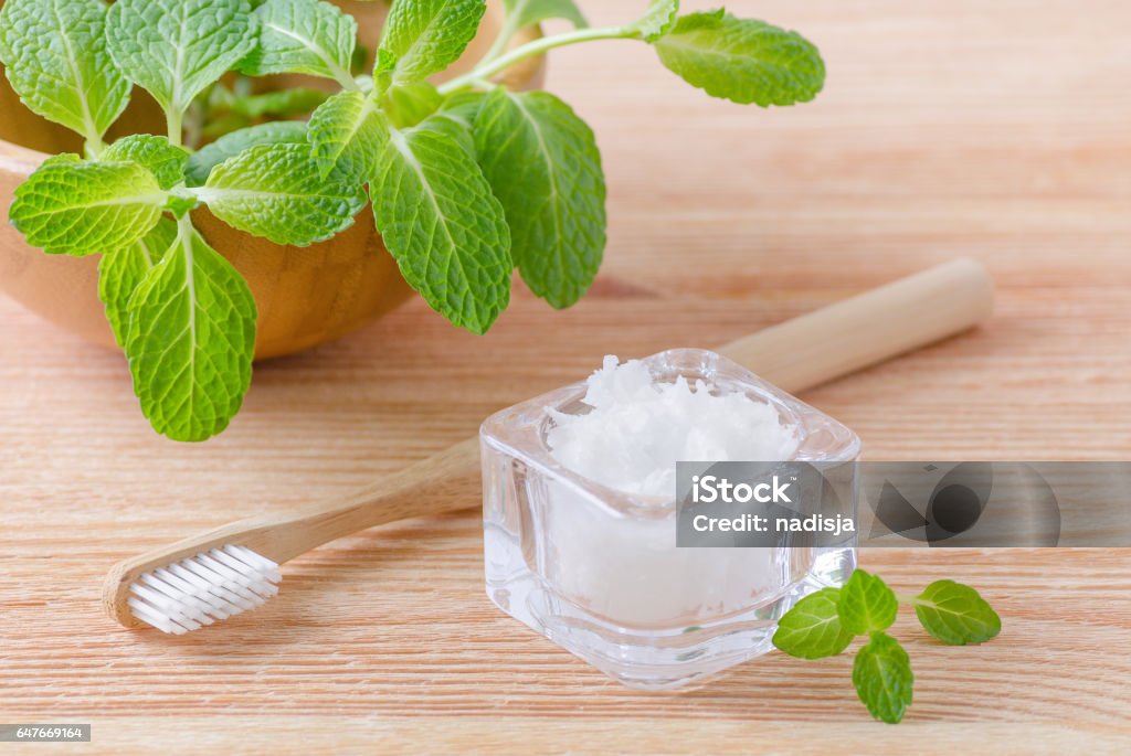 Alternative natürliche Zahnpasta Kokosnuss-Öl und Holz Zahnbürste Closeup, Minze auf Holz - Lizenzfrei Ausrüstung und Geräte Stock-Foto