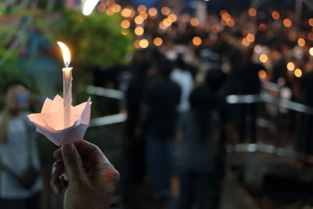 hand of man hold candle flame light at night background - coherence imagens e fotografias de stock