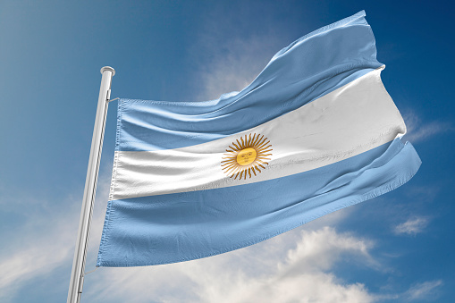 Argentinian flag is waving at a beautiful and peaceful sky in day time while sun is shining.