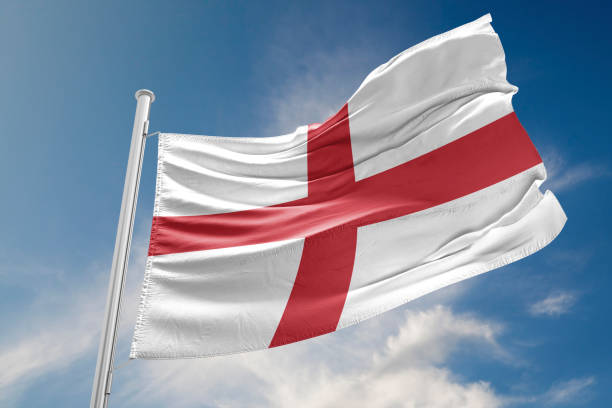 english flag is waving against blue sky - english flag fotos imagens e fotografias de stock