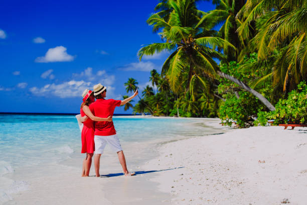 istock Young happy couple making a selfie on beach 647688412