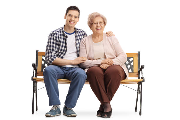 istock Young man and an elderly woman sitting on a bench 647688554