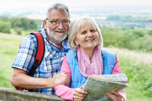 istock Senior Couple Hiking In Countryside With Map 647692400