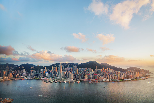 Hong Kong, China - May 1, 2018: Hong Kong skyline cityscape downtown skyscrapers over Victoria Harbour on sunset. Hong Kong, China