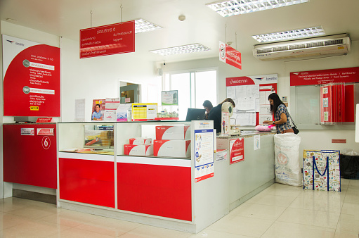 Thai people sending parcel post and employee service customer by fast and friendly at post office on January 25, 2017 in Bangkok, Thailand