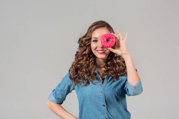 istock The smiling girl on gray studio background with round cake 647706756