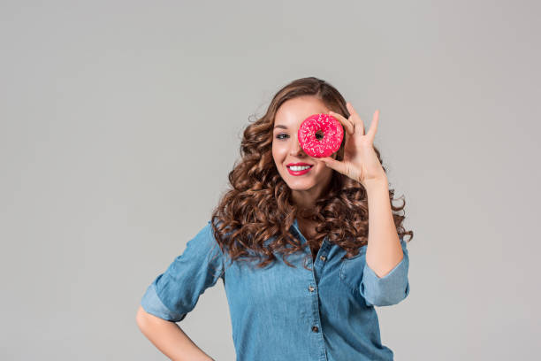 istock The smiling girl on gray studio background with round cake 647706806