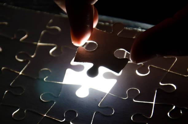 istock A creative completes the black puzzle putting the last missing piece blue light 647707758