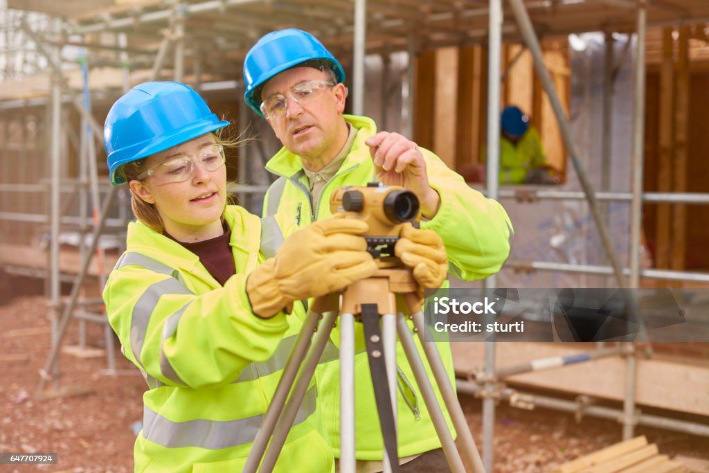 aprendiendo a utilizar el nivel de constructor del trabajador de la construcción - Foto de stock de Aprendiz libre de derechos