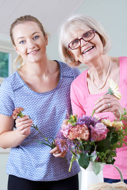 istock Senior Woman With Teacher In Flower Arranging Class 647710688