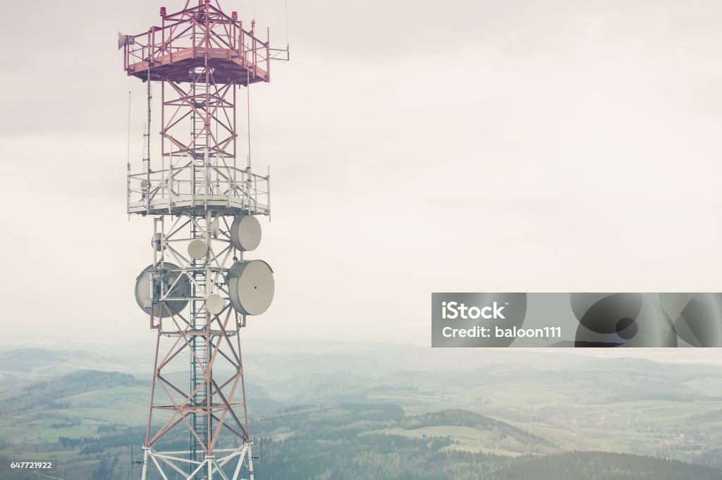 Radio mast over a cloudy valley background Communications Tower Stock Photo