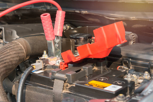 istock Charging battery car with electricity trough jumper cables 647724484