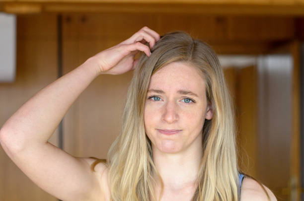 istock Young blond woman scratching her head 647725558