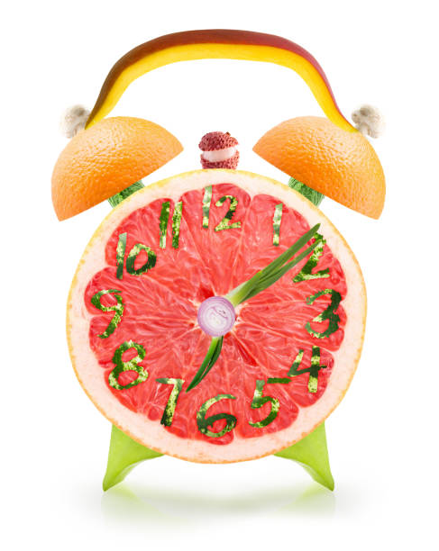 istock Food alarm clock with fruits on white background 647728348