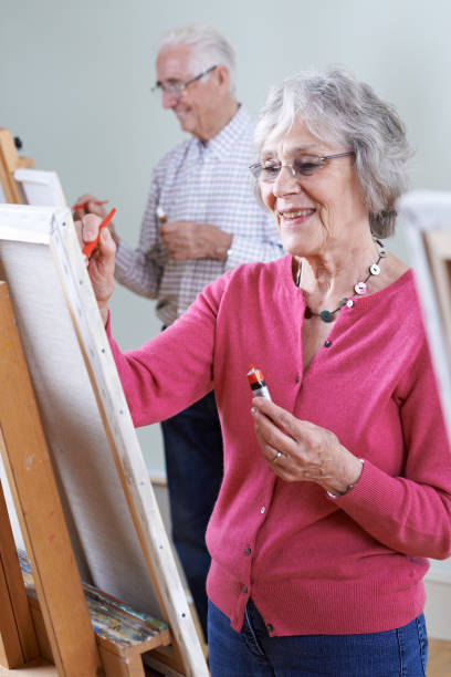 istock Seniors Attending Painting Class Together 647731656