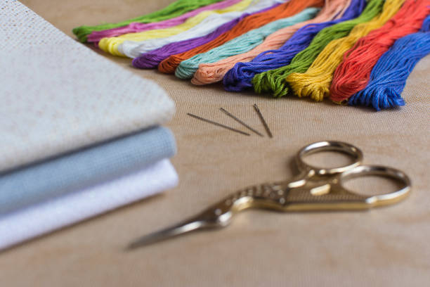 istock Cross-stitch set for embroidery consisting of canvas, needles, threads  and scissors. Focus on the colourful thread 647735412