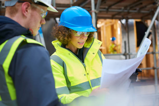 kobieta kierownik budowy instruując pracownika . - architect construction hardhat planning zdjęcia i obrazy z banku zdjęć