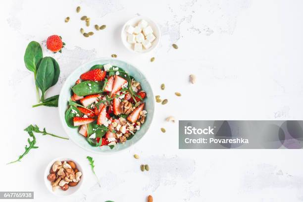 Spinach Leaves Sliced Strawberries Nuts Feta Cheese On White Background Stock Photo - Download Image Now