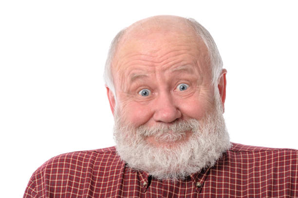 Handsome bald and bearded senior man shows surprised smile grimace or facial expression, isolated on white background