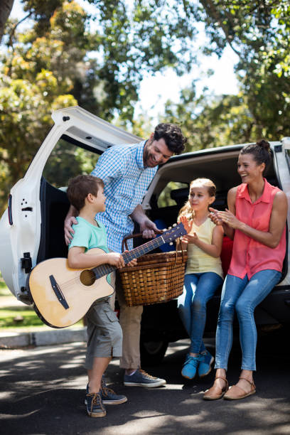 padre felice che interagisce con suo figlio vicino all'auto - car family picnic vacations foto e immagini stock