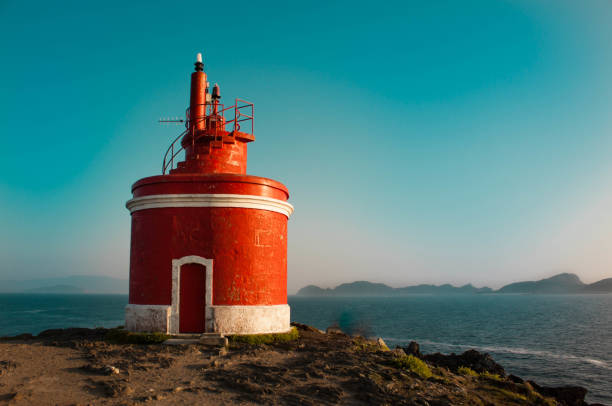 istock Red lighthouse on the coast at sunset with sea backgrounds 647776162