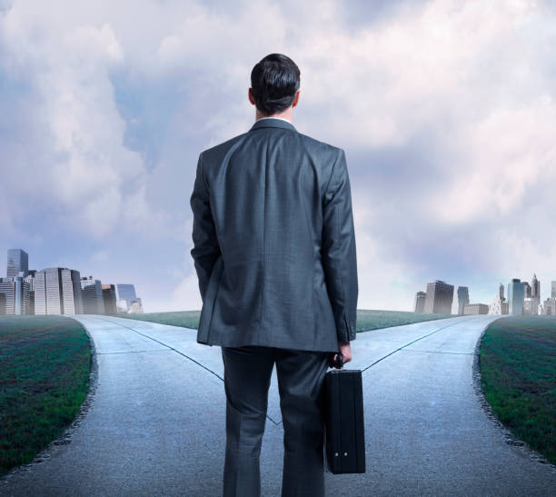 istock Businessman Stands At Fork In The Road 647776500