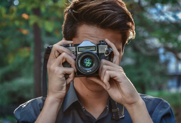 istock Hipster guy photographer with retro camera 647777532