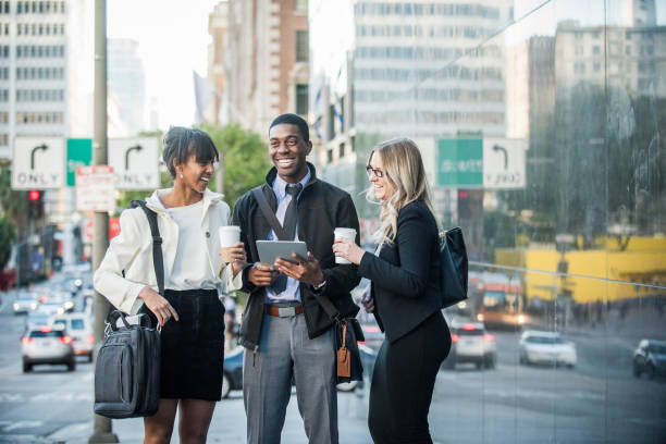 istock Three Multi Ethnic Millennials in business attire with mobile devices and coffee in Downtown Los Angeles 647779946