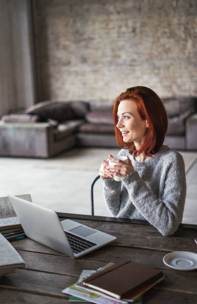istock Young woman working in a loft apartment with a laptop computer 647783368