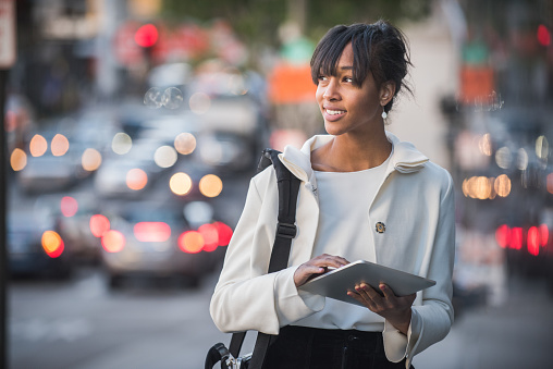 A single young African American female business person, using her mobile device.