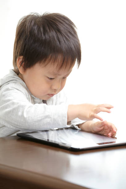 istock Children looking at electronic tablet with Japanese man 647786818